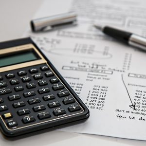 A calculator on pen resting on a balance sheet.