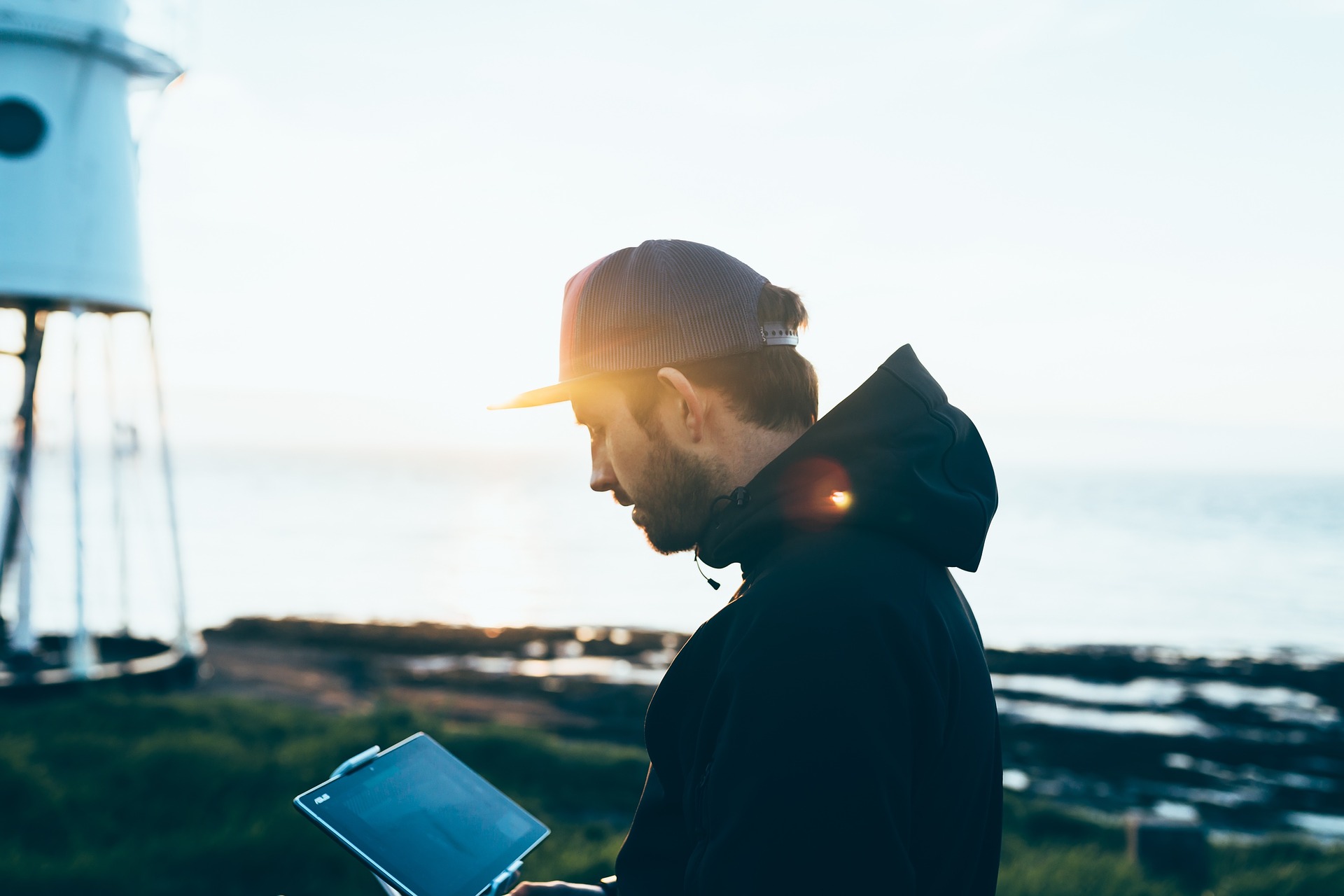 A young man looking at a tablet outside