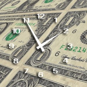 An analog clock superimposed on sheets of money